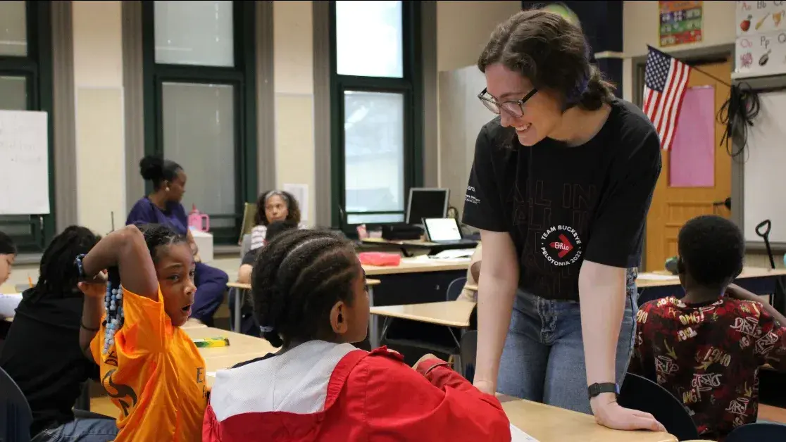 A volunteer works with elementary students on Generation Rx activities.