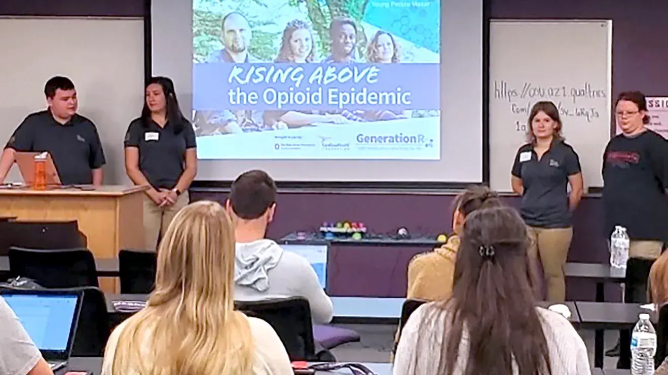 university students watching a slide show presentation about the Opioid Epidemic