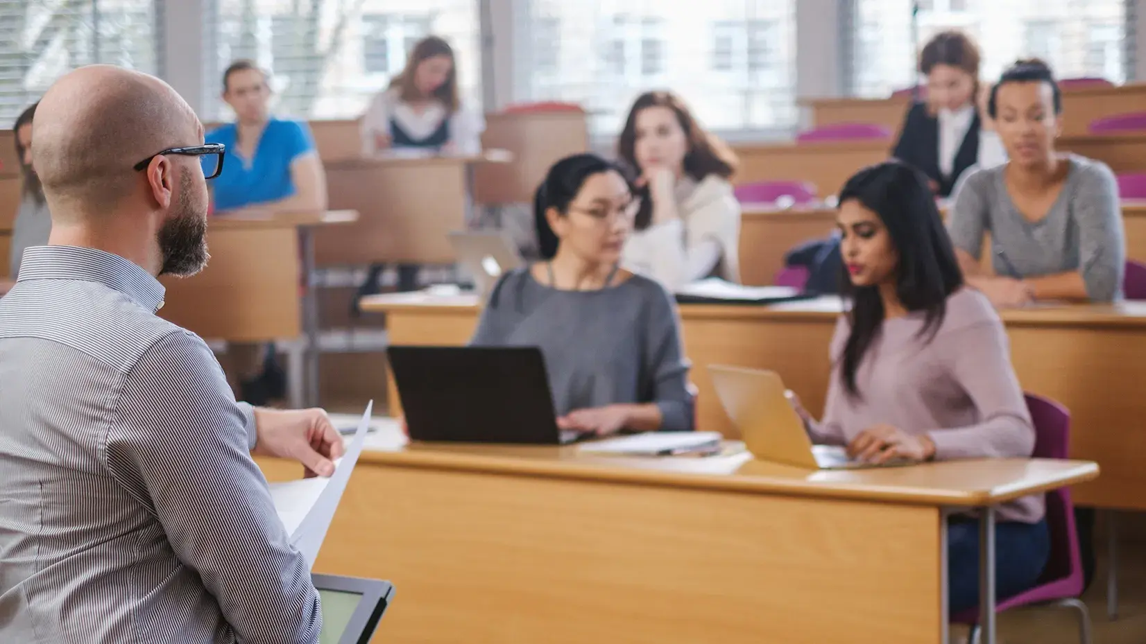 Students listen to a professor in a lecture room