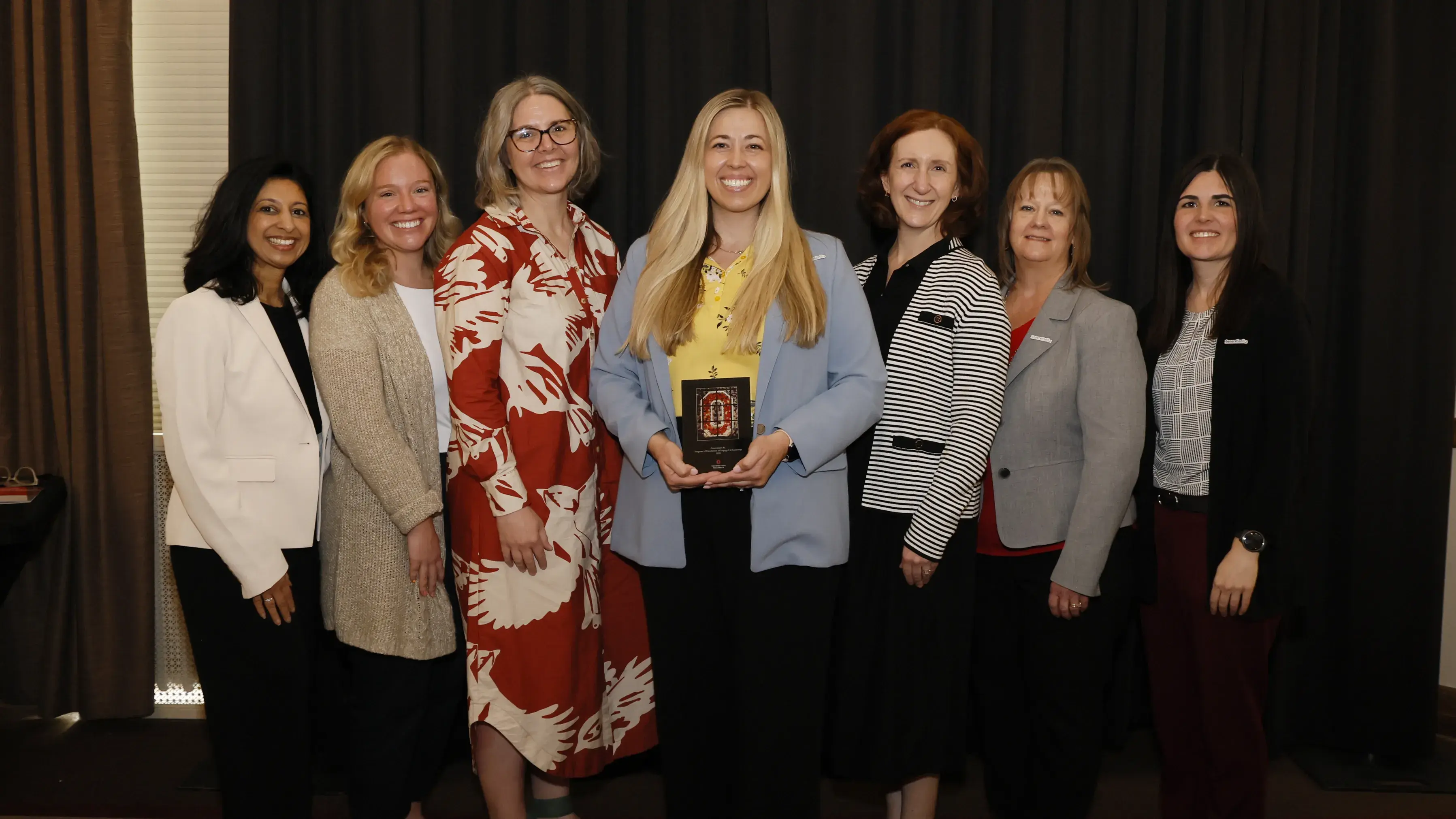 Members of Generation Rx and College of Pharmacy faculty pose together with the Program of Excellence plaque