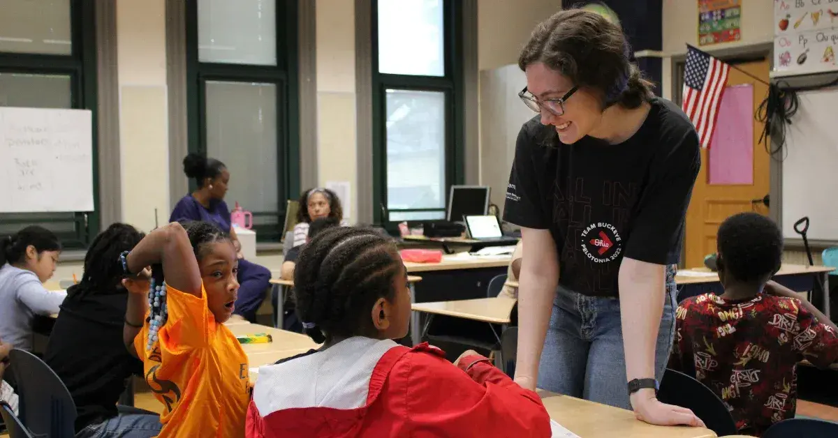 A volunteer works with elementary students on Generation Rx activities.