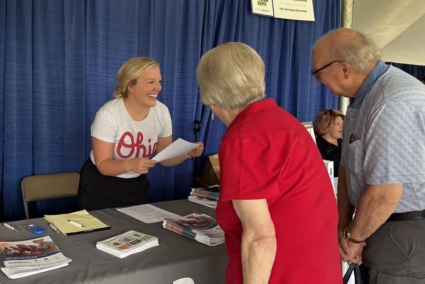 Generation Rx ambassadors handing out pamphlets to an older couple at a community event